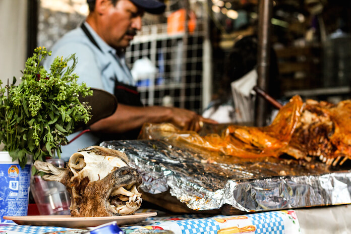 Different culture, different traditions: here this guy is advertising his meat with head of a goat.